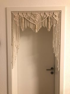 an open door with some tassels hanging from it's sides and a handle on the door