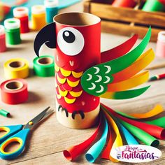 a colorful bird made out of toilet paper next to scissors and other crafting supplies