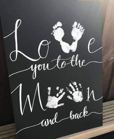 a sign that says i love you to the moon and back with hand prints on it