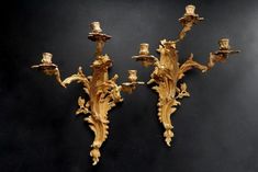 three golden wall sconces with flowers and leaves