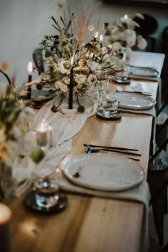 the table is set with flowers and candles