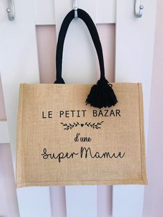 a jute bag hanging on the side of a white door with french words written across it