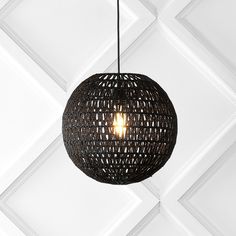 a light that is hanging from a ceiling in a room with white tiles on the walls