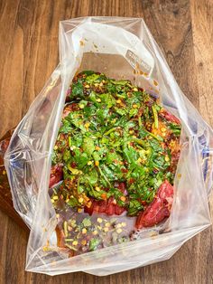 a plastic bag filled with food on top of a wooden table