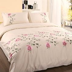 a white bed with pink roses on it