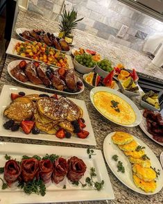 a table filled with lots of food on top of a kitchen counter next to an oven