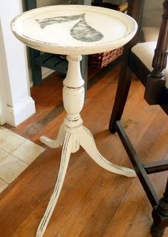 a white table with a black and white drawing on it's top sitting in front of a chair