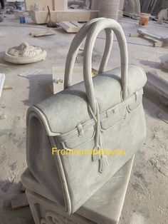 "Introducing our stunning Carved Marble Designer Handbag, a true work of art that seamlessly blends fashion and luxury. Measuring 16\" x 14\" tall and weighing an impressive 100 lbs, this handbag is crafted from the finest quality marble and features exquisite carved detailing that is sure to turn heads. The spacious interior provides ample room for all your essentials, while the sturdy handles ensure maximum comfort and durability. Perfect for those who love to make a statement, this handbag is Large Luxury Satchel, Marble Carving, Designer Handbag, Large Bag, Hand Bag, Purses And Handbags, Designer Handbags, Cocoa, Fashion Forward