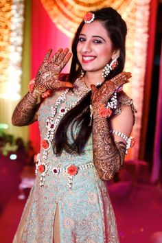 a woman in a blue and gold dress holding her hands up