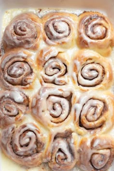 cinnamon rolls in a baking dish with icing on top