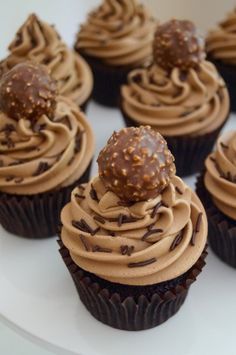 chocolate cupcakes with frosting and sprinkles on a white plate