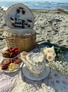 a picnic on the beach with cake and flowers