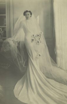 an old photo of a woman in a wedding dress with veil and flowers on it