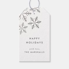 a white gift tag that says happy holidays with snowflakes hanging from the front