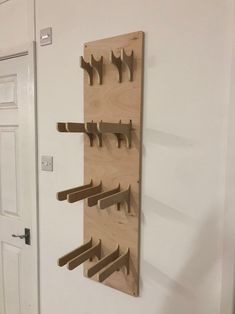 a wall mounted coat rack with wooden pegs on it