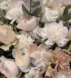 a bouquet of white and pink flowers with green leaves