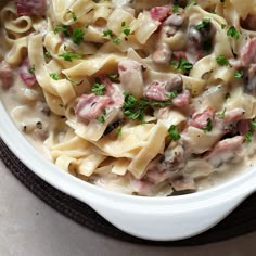 a white bowl filled with pasta and meat