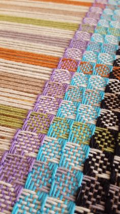 closeup of woven fabric with different colors and patterns on the table top, including multi - colored strips