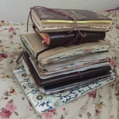 a stack of books sitting on top of a bed