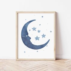 a blue moon with stars in the night sky on a white wall next to a wooden floor