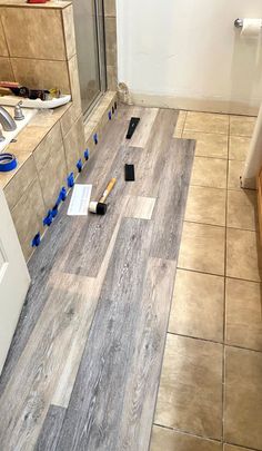 the bathroom floor is being laid out with tools on it and ready to be installed