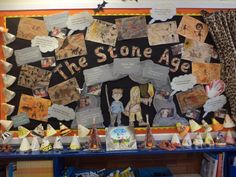 a bulletin board covered in lots of different types of papers and pictures on it with the words, the stone age