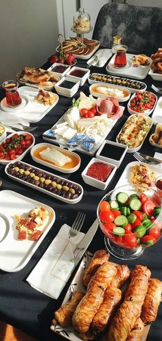 a table full of food including croissants, salads and other foods