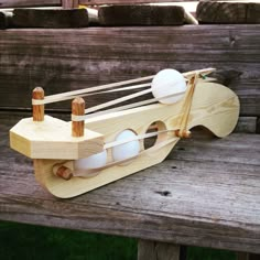 a wooden toy boat sitting on top of a wooden bench