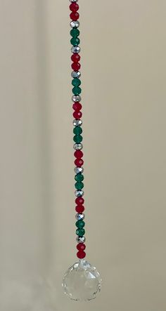 a glass beaded necklace hanging from a hook