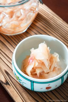 a bowl filled with food sitting on top of a wooden table next to a glass jar