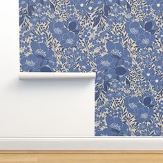 a blue floral wallpaper next to a white door