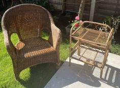 two wicker chairs sitting next to each other on the grass in front of a house