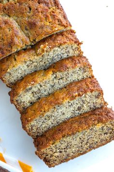 slices of banana bread on a white plate with orange peels next to the loaf