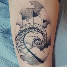 a black and white photo of a woman's leg with a ferris wheel tattoo on it