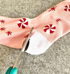 a pair of pink socks with candy canes on them and a pair of scissors