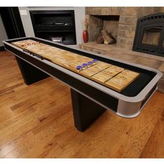 a table that is in the middle of a room with a fire place behind it