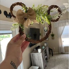 a person holding up a heart shaped wreath