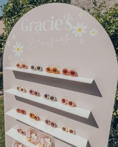 a sign that says grace's daisies on it and some donuts in front of it