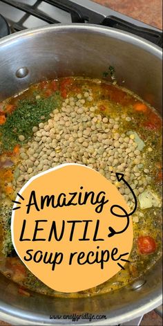 a pot filled with beans and vegetables on top of a stove next to a sign that reads amazing lentil soup recipe