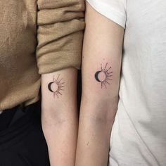 two people with matching tattoos on their arms, one is holding the other's arm