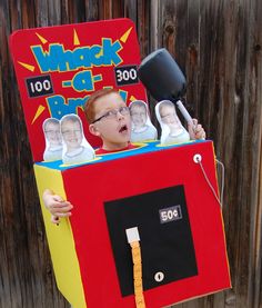 a young boy wearing a costume made to look like a man in a box with his head sticking out