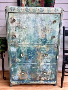 an old dresser is painted green and blue