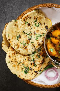 a basket filled with food next to some pita bread