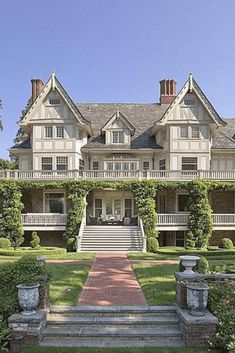 a large white house sitting on top of a lush green field