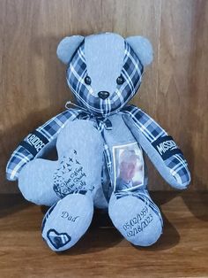 a blue teddy bear sitting on top of a wooden shelf