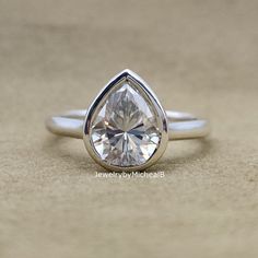 a white gold ring with a pear shaped diamond