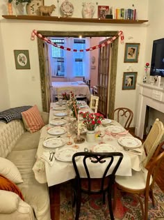 the dining room table is set with plates and place settings