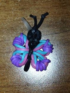 a hair clip made out of rubber beads with scissors on it sitting on a table