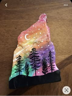 an image of a painted rock with trees on it