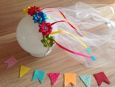 a vase filled with flowers and ribbons on top of a wooden table next to streamers